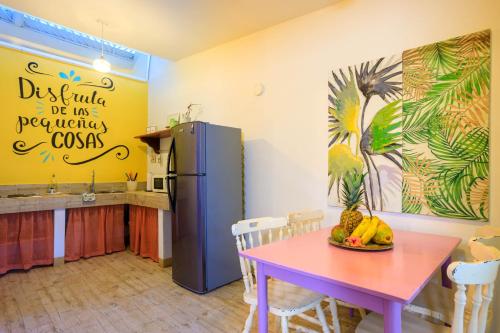 a kitchen with a table and a refrigerator at Kalawala in Puerto Viejo