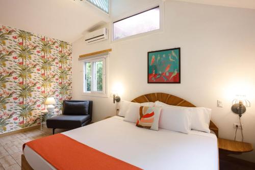 a bedroom with a bed and a chair in a room at Kalawala in Puerto Viejo