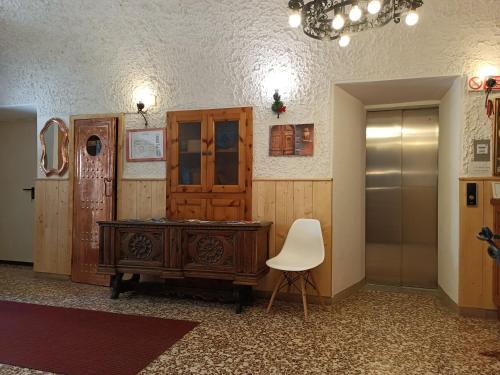a room with a wooden desk and a white chair at Hotel Gufo in Bormio