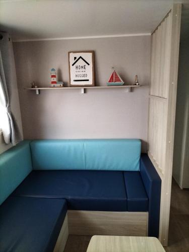 - un canapé bleu dans une pièce avec des étagères dans l'établissement Mobil-home Narbonne-Plage, à Narbonne-Plage