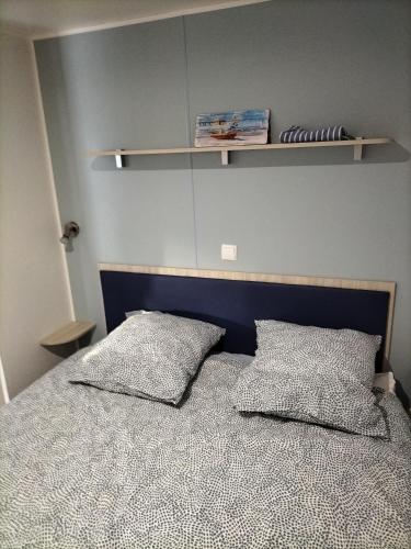 une chambre avec un lit avec deux oreillers dessus dans l'établissement Mobil-home Narbonne-Plage, à Narbonne-Plage