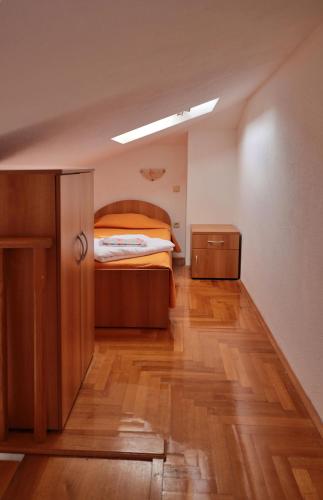 a bedroom with a bed and a wooden floor at Apartment Carole in Trogir