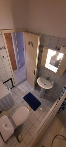 La salle de bains est pourvue de toilettes et d'un lavabo. dans l'établissement KANALI HOLIDAYS APARTMENT, à Kanali