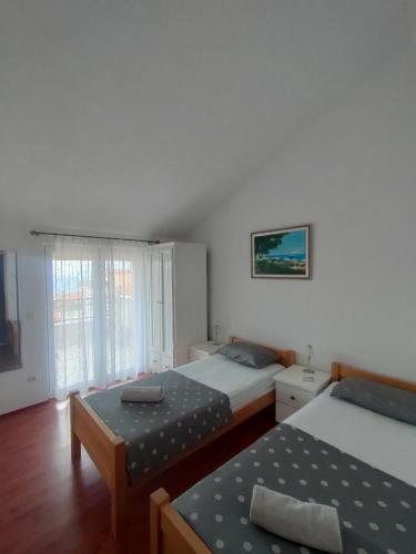 a hotel room with two beds and a table at Baška Voda - Apartmani Vesna in Baška Voda