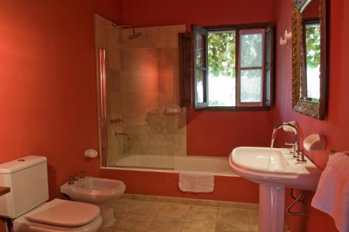 a bathroom with a toilet and a tub and a sink at Posada Verde Oliva in Maipú
