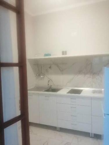 a white kitchen with a sink and a counter at Villa Laura Residence Hotel Apartments & Studios in Ascea