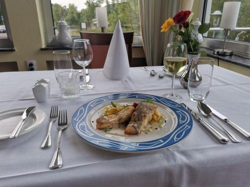 a table with a plate of food on a table at Hotel Haus am See in Simmerath