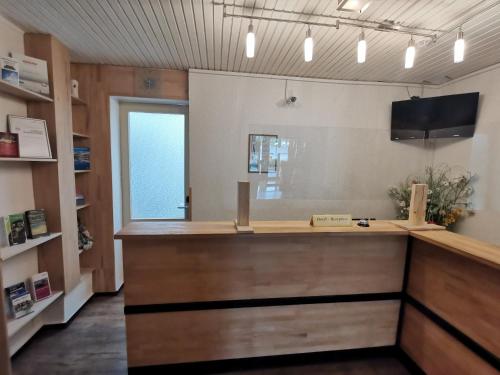 a shop with a wooden counter in a room at Hotel Haus am See in Simmerath