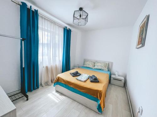 a bedroom with a bed with blue curtains at Apartament Zarnesti „Saturn” in Zărneşti