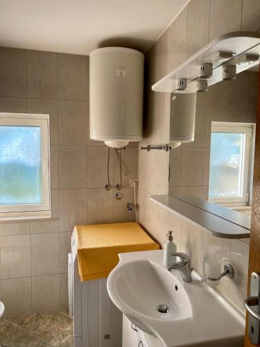 a bathroom with a sink and two windows at Apartmani Luka in Korčula