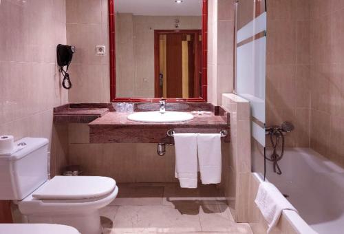 y baño con lavabo, aseo y bañera. en Hostal Plaza Mayor, en Torrejón de Ardoz