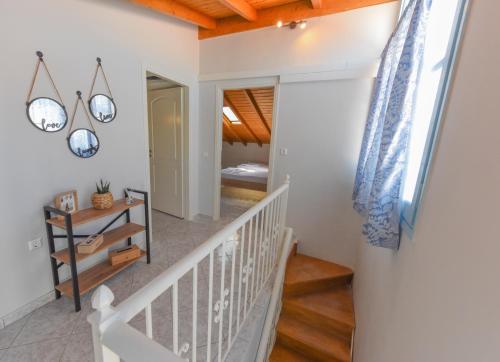 uma escadaria numa casa com paredes brancas e tectos em madeira em DEJA BLUE Maisonette em Kokkari