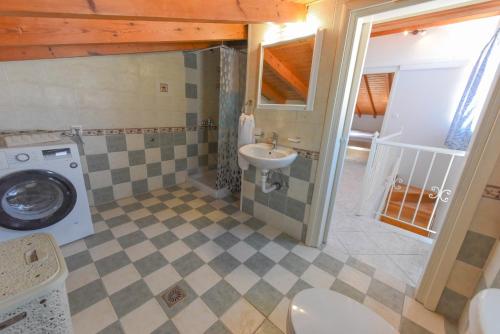 La salle de bains est pourvue d'un lavabo et d'un lave-linge. dans l'établissement DEJA BLUE Maisonette, à Kokkari