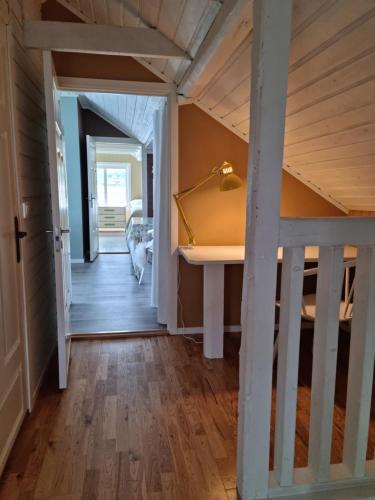 a hallway of a house with a staircase and a desk at Loftsleilighet midt i sentrum in Skjervøy