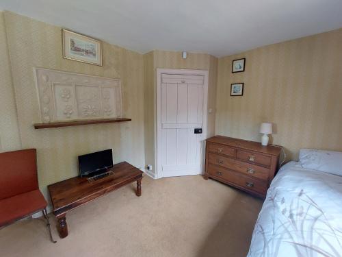 a bedroom with a bed and a desk with a laptop on it at The Manor House, Curry Mallet in Taunton