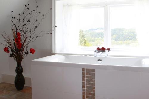 baño con lavabo blanco y ventana en Sawrey House, en Near Sawrey