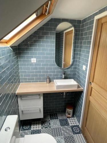 a bathroom with a sink and a mirror at Le Gîte de Jean Thevenin, avec parking gratuit in Épernay