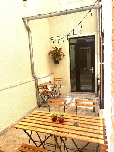 a patio with two benches and a table and chairs at Le Gîte de Jean Thevenin, avec parking gratuit in Épernay