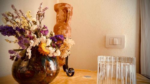 a vase of flowers and a statue on a table at B&b Domo La Laguna in Càbras
