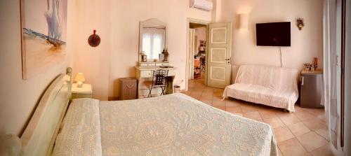 a bedroom with a bed and a chair and a television at B&b Domo La Laguna in Càbras