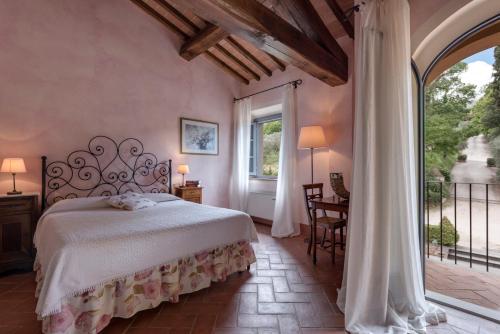 a bedroom with a bed and a large window at Il Borghetto Tuscan Holidays in San Gimignano