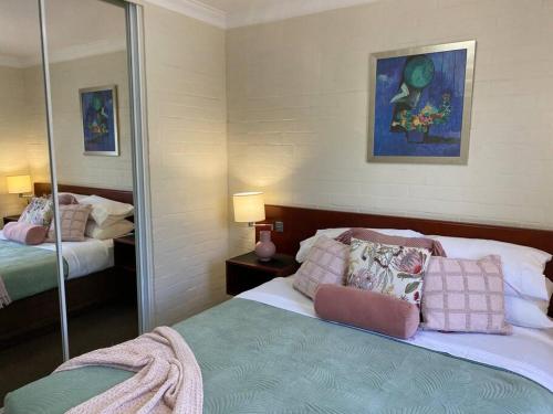 - une chambre avec 2 lits et un miroir dans l'établissement SUBI CENTRAL CLOSE CBD HOSPITALS WIFI NETFLIX WINE, à Perth