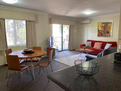 a living room with a couch and a table and chairs at SUBI CENTRAL CLOSE CBD HOSPITALS WIFI NETFLIX WINE in Perth