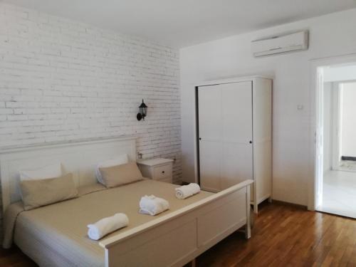 a white bedroom with a bed and a white brick wall at Villa Allegra 1 in Lovran