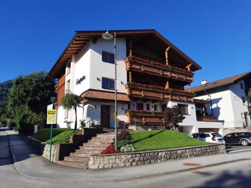 a large building with a staircase in front of it at Pension Bergheim in Reith im Alpbachtal
