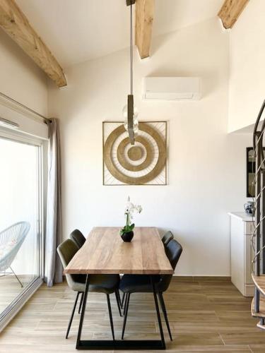 une salle à manger avec une table et des chaises en bois dans l'établissement Duplex Centre Ville - 50m de la Plage - Clim - Garage - Netflix, au Grau-du-Roi