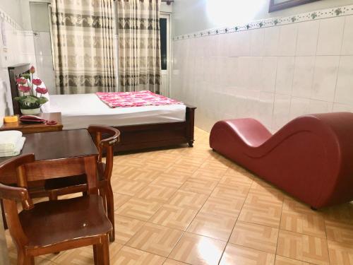 a room with a bed and a table and a chair at Khách Sạn Hồng Hà 2 in Ho Chi Minh City