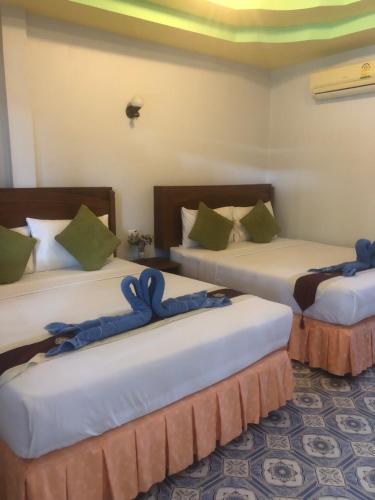 um quarto com três camas com arcos azuis em Sunsea Resort em Baan Khai