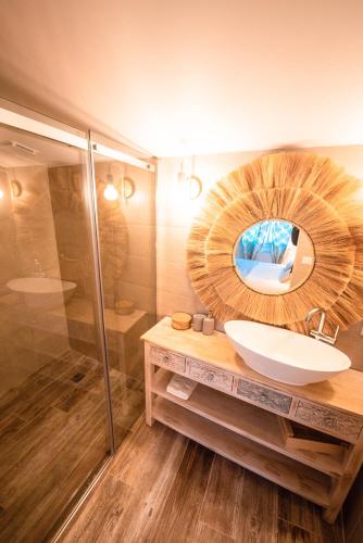 une salle de bain avec un lavabo et un miroir dans l'établissement La Bohème. Maison de village cosy, jardin et spa., à Octon