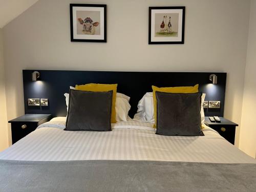 a bedroom with a large bed with yellow pillows at Stable Court Apartments in Antrim