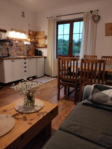 een keuken en woonkamer met een tafel en stoelen bij SielskoAnielsko w Beskidzie Niskim in Męcina Wielka