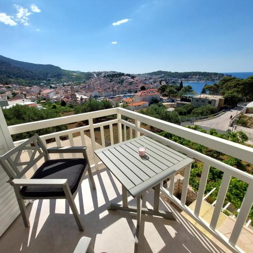 a wooden table and a chair on a balcony at Vila Luka in Hvar