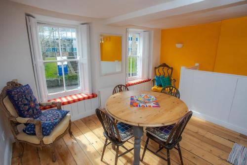 a dining room with a wooden table and chairs at Reckless House. Forest Of Dean.Home Whilst Away. in Coleford