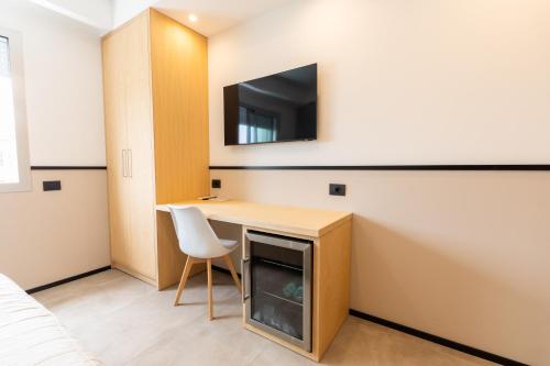 a room with a desk and a tv on a wall at Antares Rooms and Suites in Olbia