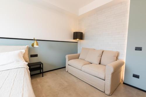 a living room with a couch and a bed at Antares Rooms and Suites in Olbia