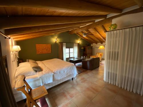 een slaapkamer met een groot bed en een woonkamer bij Valle del Arroyo Casas Rurales - B&B - Solo adultos in Cortelazor