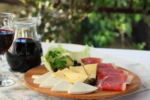 a plate of cheese and meats and a glass of wine at Guest House Željko Klarić in Skradin