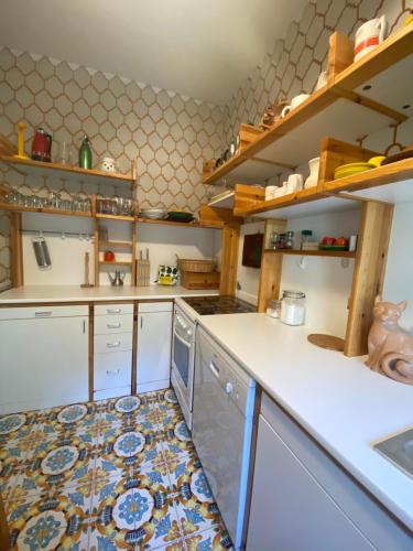 uma cozinha com uma bancada branca e alguns pratos em La Casa di Renata by PortofinoVacanze em Rapallo