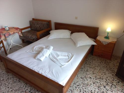 a bedroom with a bed with a chair and a table at Pension Marina in Kinira
