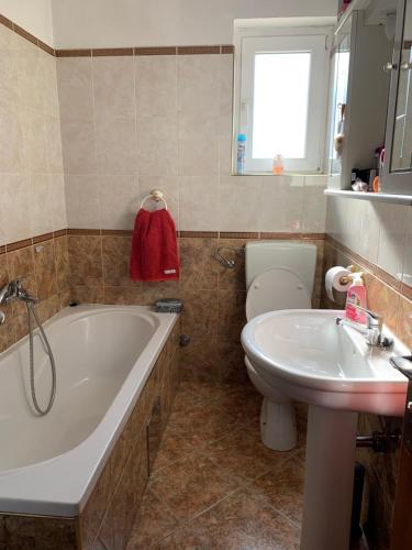 ein Badezimmer mit einer Badewanne, einem WC und einem Waschbecken in der Unterkunft apartment for 4-6 Persons second floor in Ljubač