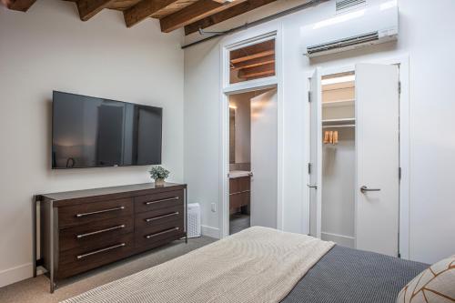a bedroom with a flat screen tv and a bed at Elevation Lofts Hotel in Asheville