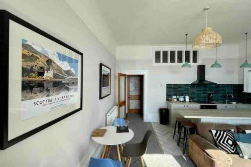 a kitchen and living room with a large picture on the wall at Westbay Seafront Apartment in Oban