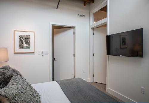 a bedroom with a bed and a flat screen tv at Elevation Lofts Hotel in Asheville