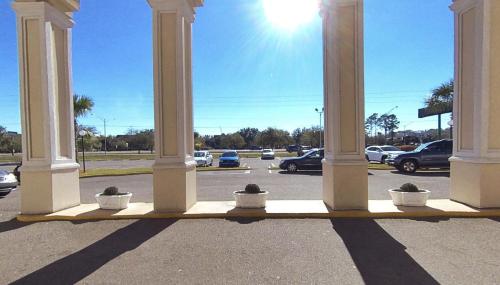 a group of pillars with cars parked in a parking lot at Windsor Inn of Jacksonville in Jacksonville