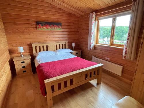 a bedroom with a bed in a log cabin at Deveron Valley Cottages in Marnoch