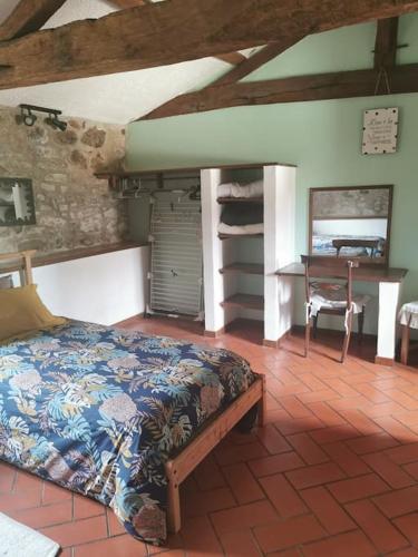 une chambre avec un lit et un bureau dans une pièce dans l'établissement Gîte de La Pomerie, à Chiché
